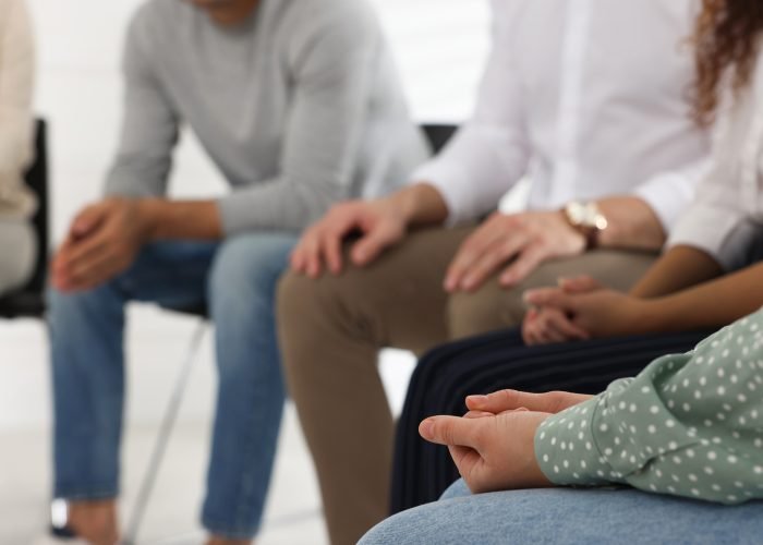 People at group therapy session indoors, closeup